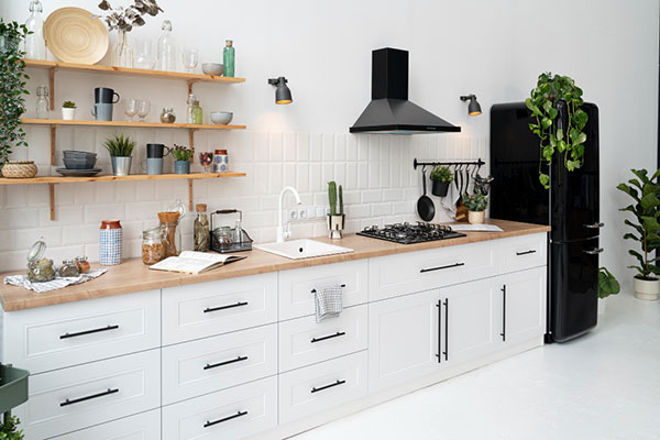 Contemporary kitchen design with pristine white cabinets and sophisticated black appliances