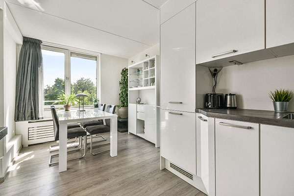 bright kitchen featuring white cabinets and a wooden dining table